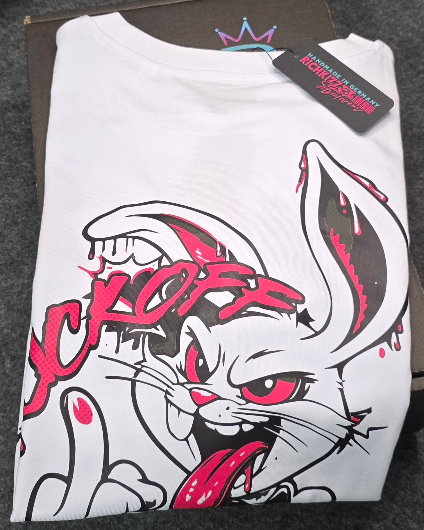 Angesagtes Provokant freches Damen T-Shirt Bad Bunny "fck off", aus reiner Bio-Baumwolle – weil echte Qualität keine Kompromisse kennt. Das Organic Singlejersey besticht durch seine klassische Schnittform und beeindruckt.
Hergestellt in Deutschland,
100% gekämmter ringgesponnener Bio-Baumwolle
180 GSM bietet es die perfekte Balance zwischen Tragekomfort und Langlebigkeit
Nachhaltigkeit trifft auf unverfälschten Style